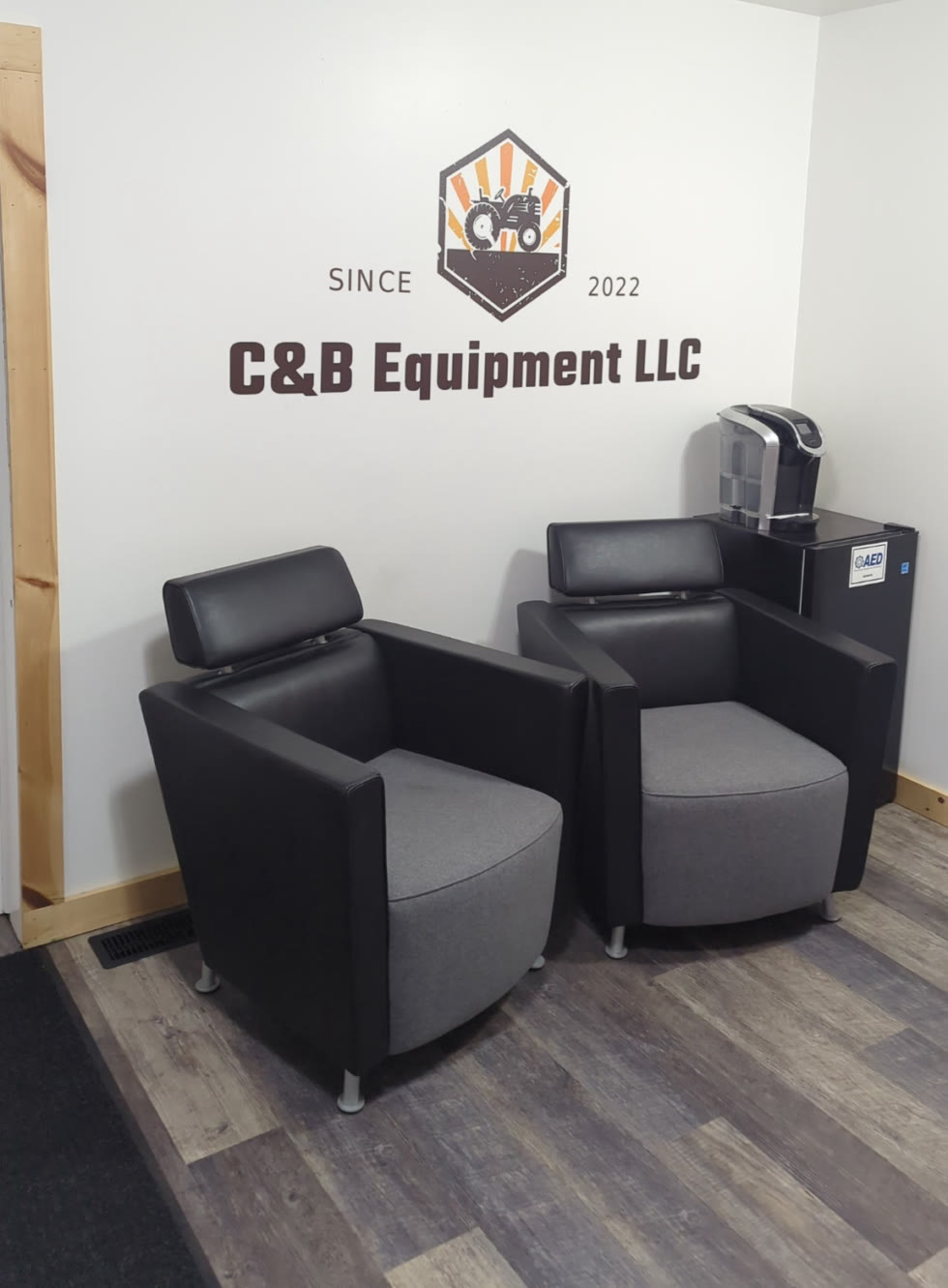 Reception wall printed with a tractor emblem and the name C&B Equipment LLC.